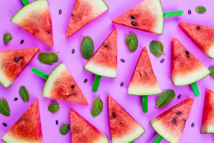 Watermelon slices on sticks with mint leaves