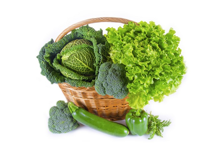 Vegetables in a wicker basket: cabbage, lettuce, broccoli, zucchini, bell pepper