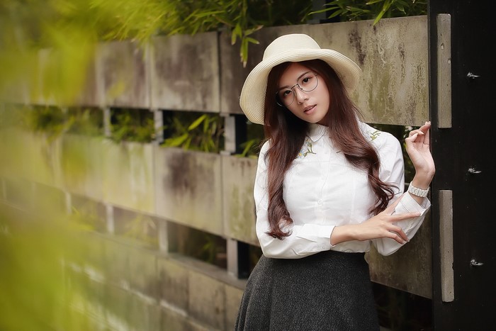 Woman in hat and glasses wearing a formal shirt