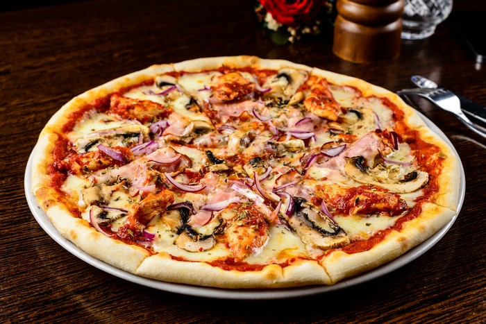 Pizza with ham, mushrooms, and red onions