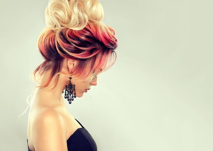 Woman with colorful updo and black earrings
