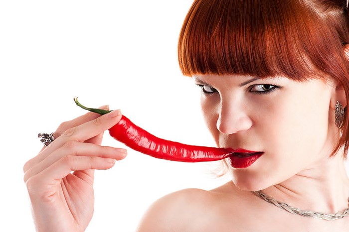 Woman with red hair holding a chili pepper