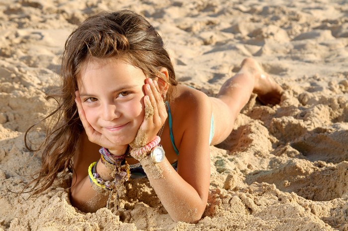 Smiling Little Girl Lying on Sandy Beach 4K
