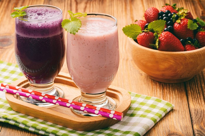 Two berry smoothies with strawberries and blueberries