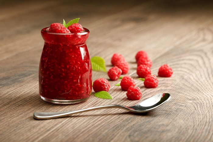 Raspberry Jam in a Jar with Spoon and Raspberries