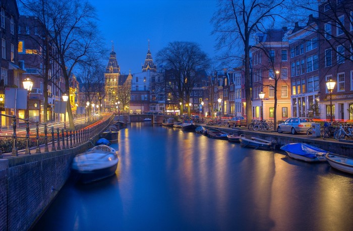 Amsterdam canal at dusk with boats and buildings