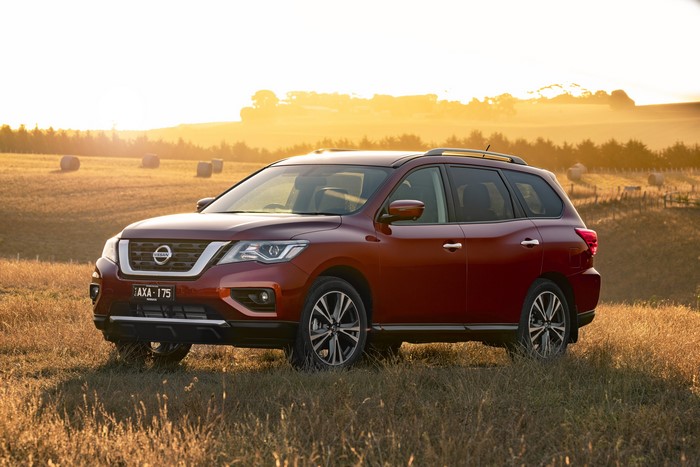 Red Nissan Pathfinder Ti SUV in a field