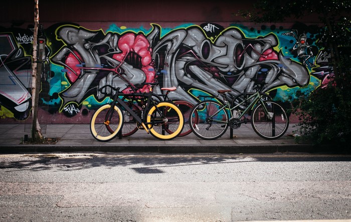 Graffiti wall with bicycles on a street