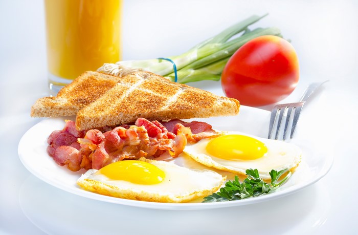 Breakfast with Bacon, Eggs, Toast, Juice, Tomato, and Scallions