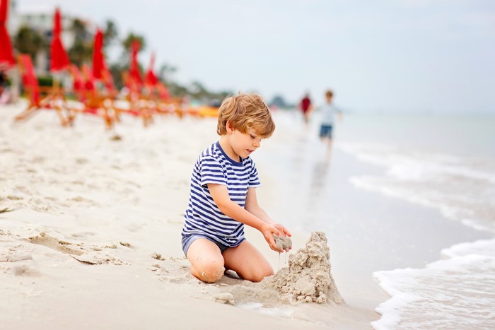Boy building sandcastle on beach