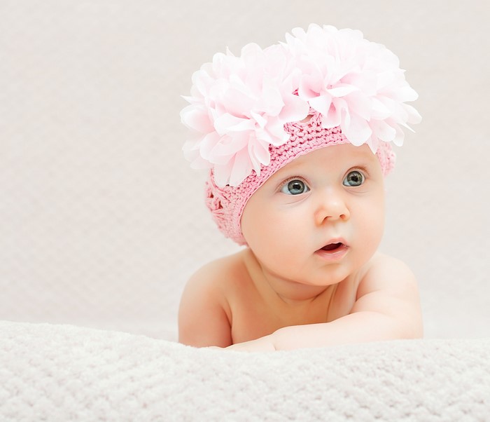 Baby wearing a pink flower hat