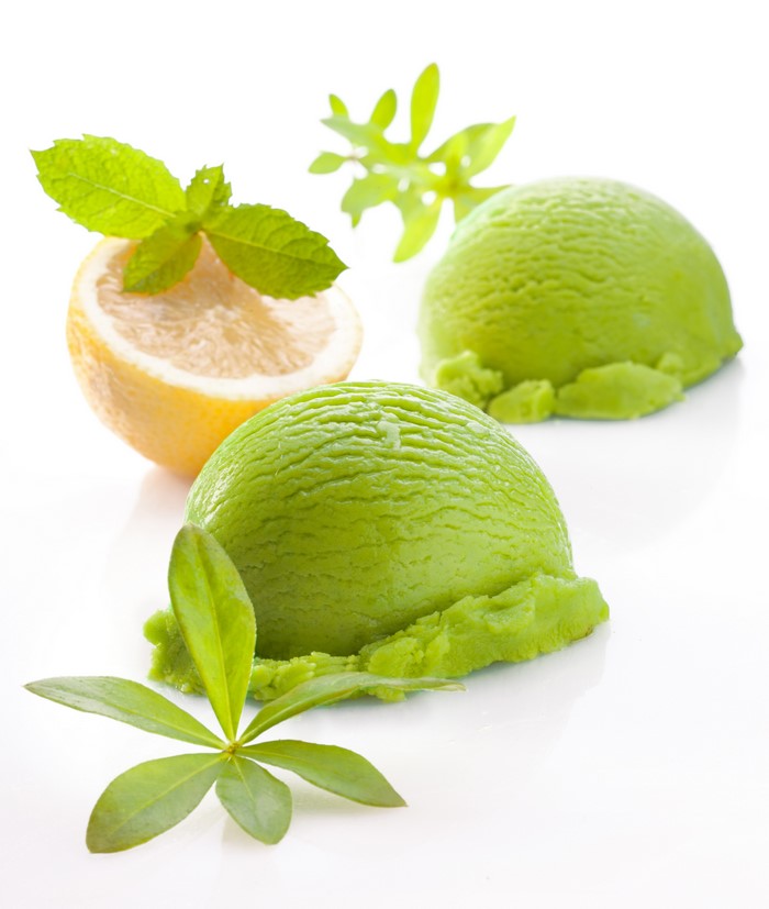 Two scoops of green ice cream with lemon and mint