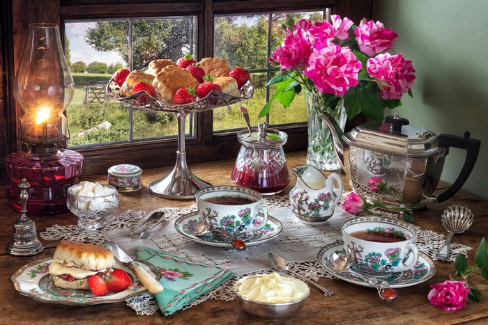 Still-life of a tea set with roses and scones