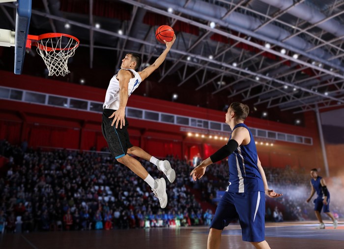 Basketball player dunking in a stadium