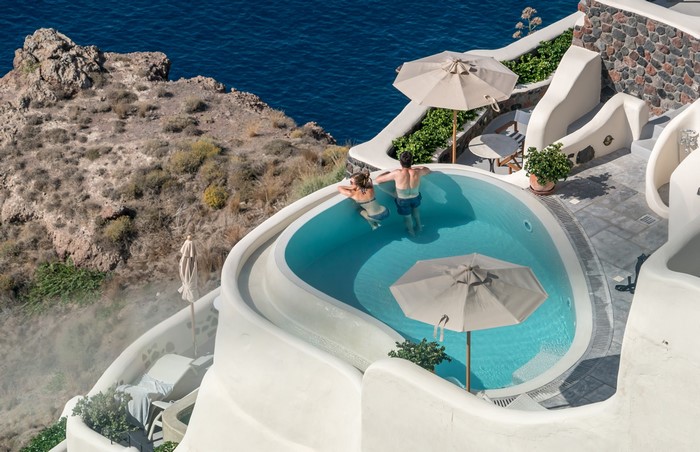 Couple relaxing in a private pool in Oia, Santorini, Greece