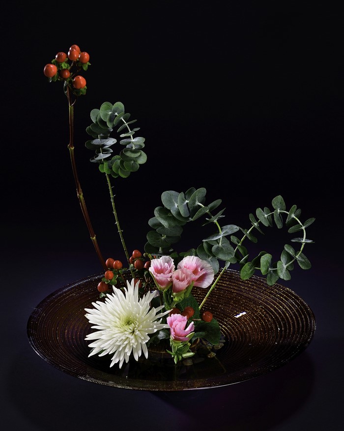 Ikebana arrangement with Chrysanthemums, Eustoma, and branches