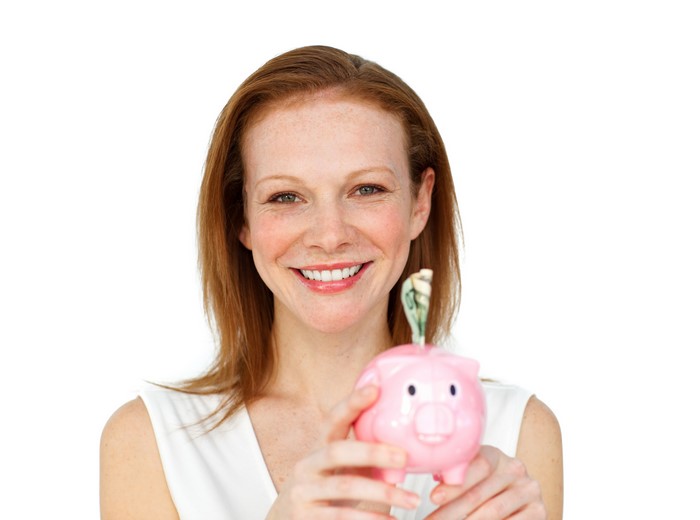 Woman holding a pink piggy bank with money