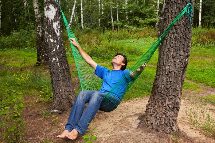 Man resting in a hammock between trees