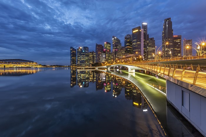 Singapore skyline with bridge and reflections at dusk