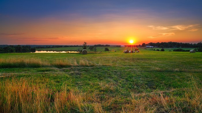 Sunset over a field with hay bales in Missouri, USA