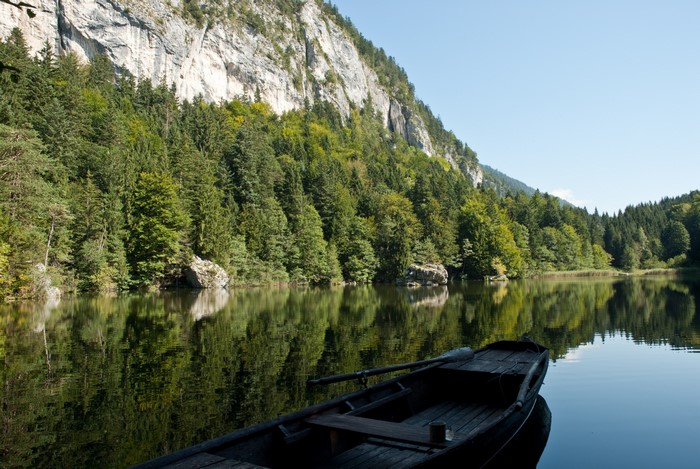 Boat on a lake with mountains and forest in Austria