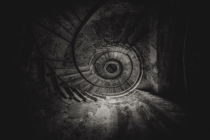 Black and white bottom view of old spiral stairs