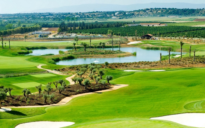 Golf course with a lake and surrounding landscape