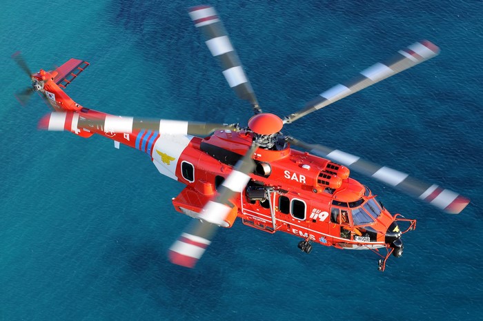 Red SAR Helicopter Flying Over Blue Water
