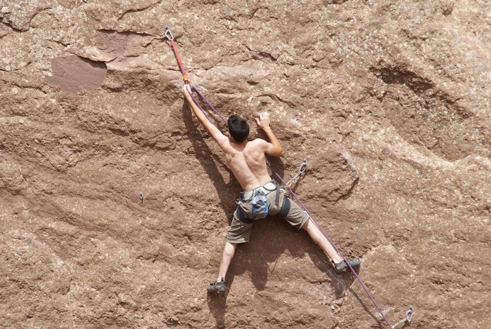 Man rock climbing on a textured cliff face