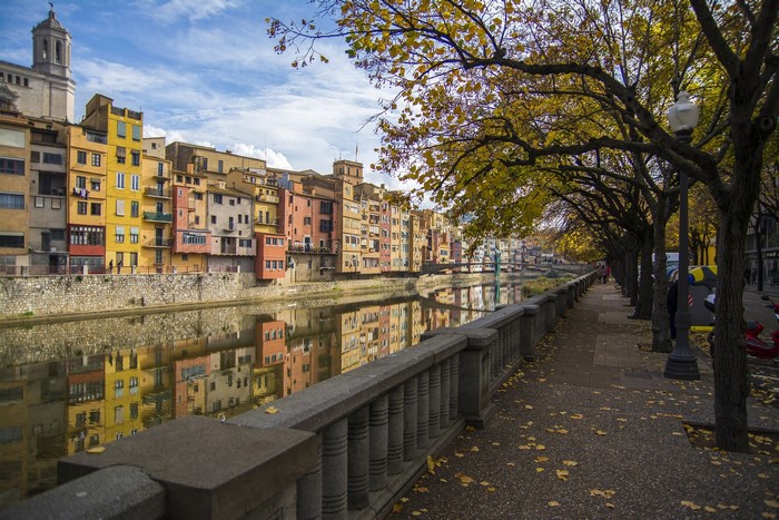 Colorful houses along the Onyar River in Girona, Spain during autumn.