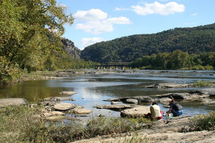 People by the Potomac River with a bridge in the background