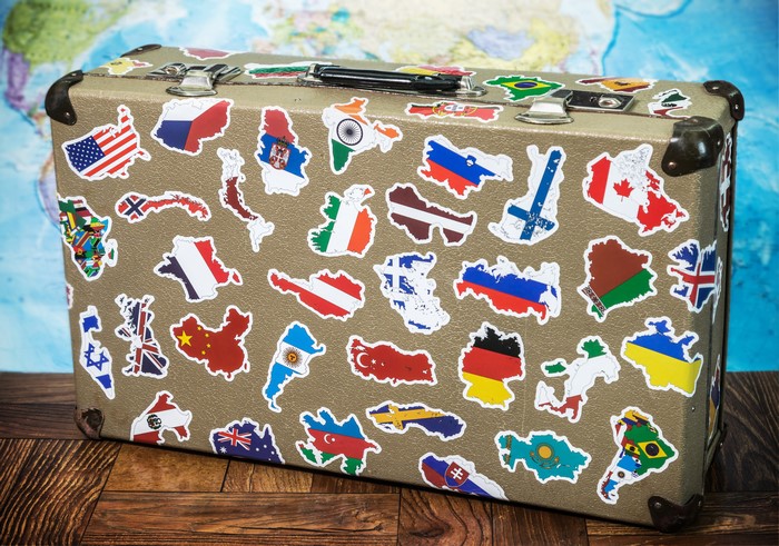 Suitcase covered in country flag stickers