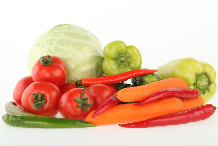 Assortment of fresh vegetables including tomatoes, cabbage, bell peppers, carrots, and chili peppers