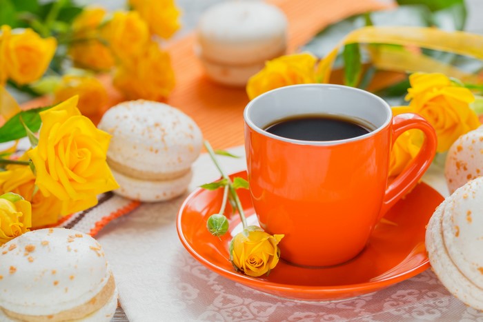 Coffee cup with yellow roses and macarons