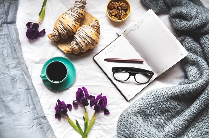 Coffee, Croissants, Notepad, Glasses, and Irises on a Bed