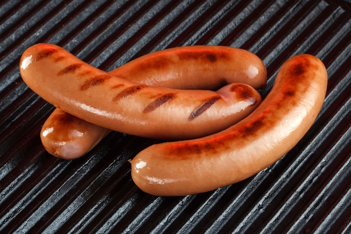 Three Vienna sausages on a grill