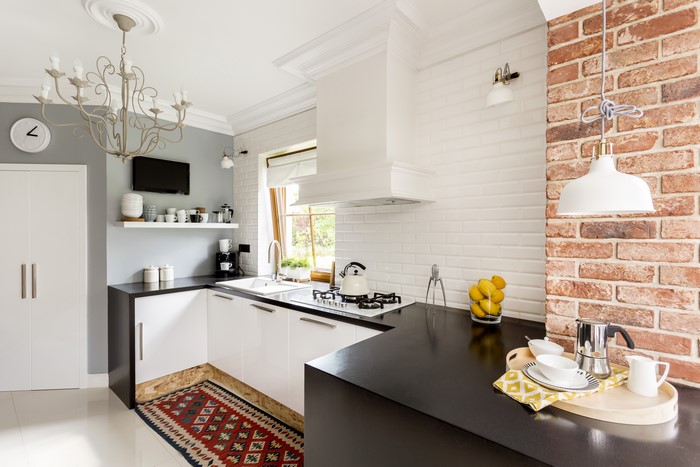 Modern Kitchen with Brick Accent Wall and Chandelier