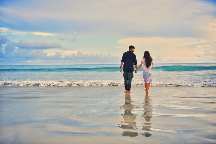 Couple walking on a beach at sunset