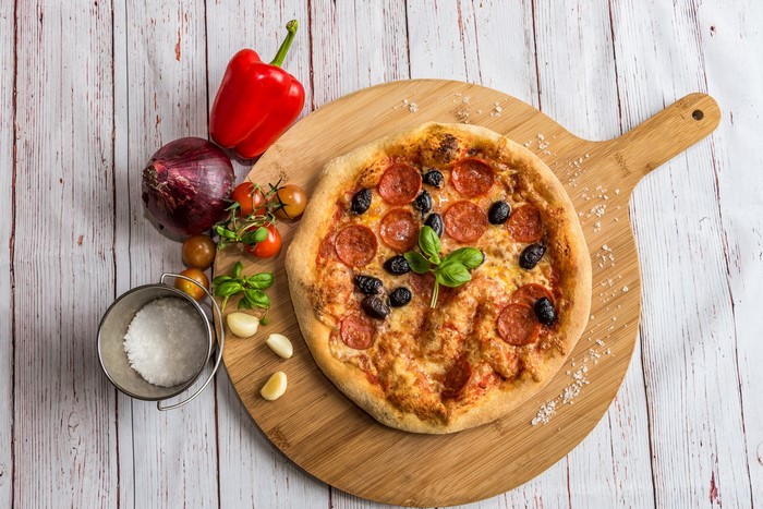 Pepperoni Pizza with Olives and Basil on Cutting Board