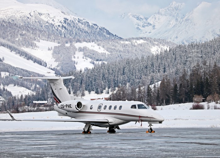 Private jet CS-PHE on snowy airfield with mountains