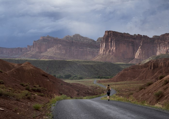 Woman running on road in Capitol Reef National Park, Utah