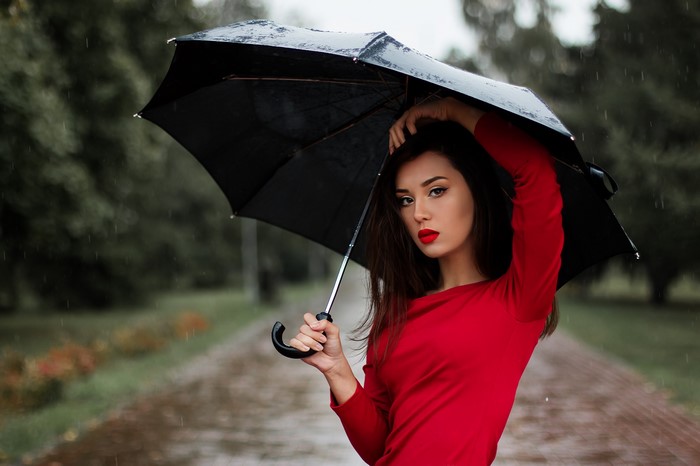 Brunette girl with umbrella in the rain