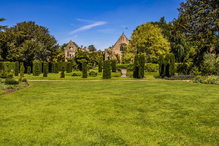 Nymans Gardens in the United Kingdom with manicured shrubs and a lawn