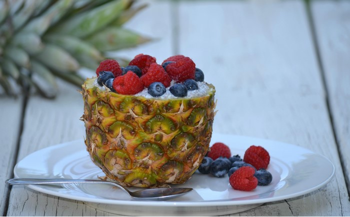 Pineapple bowl with berries and yogurt on a plate