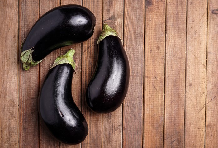 Three eggplants on wood planks