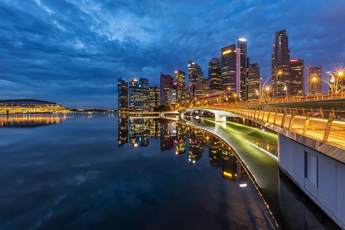 Singapore skyline and bridge at dusk with reflections