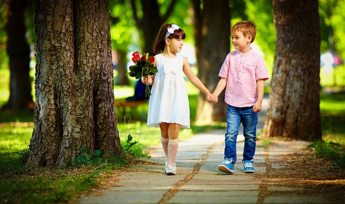 Children walking in a park with flowers