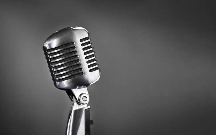 Silver vintage microphone on gray background