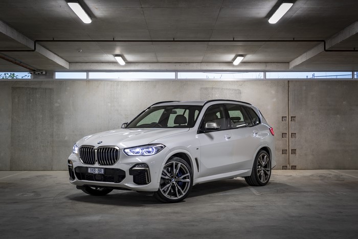 White BMW X5 M50d parked in a concrete garage