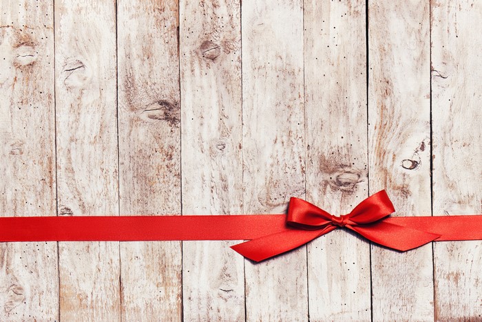 Red ribbon bow on weathered wood planks